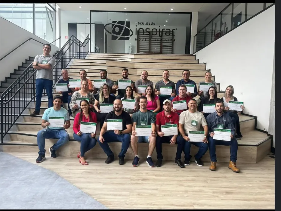 Turma segurando certificados da Segbem na escadaria da Faculdade Inspirar