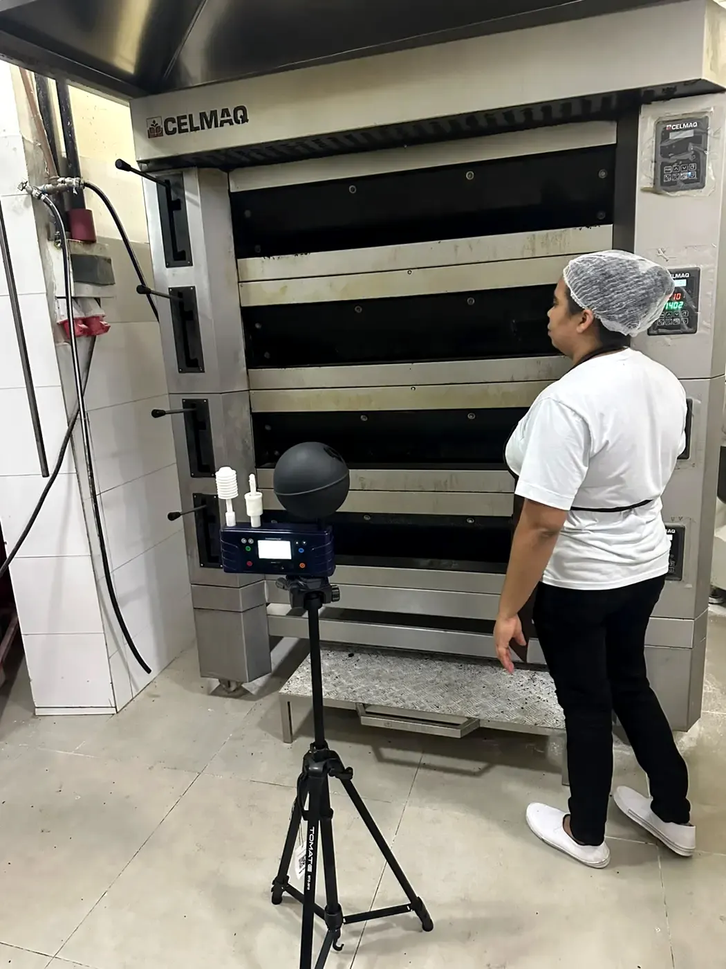 Avaliação de calor com termômetro de globo ao lado de forno industrial