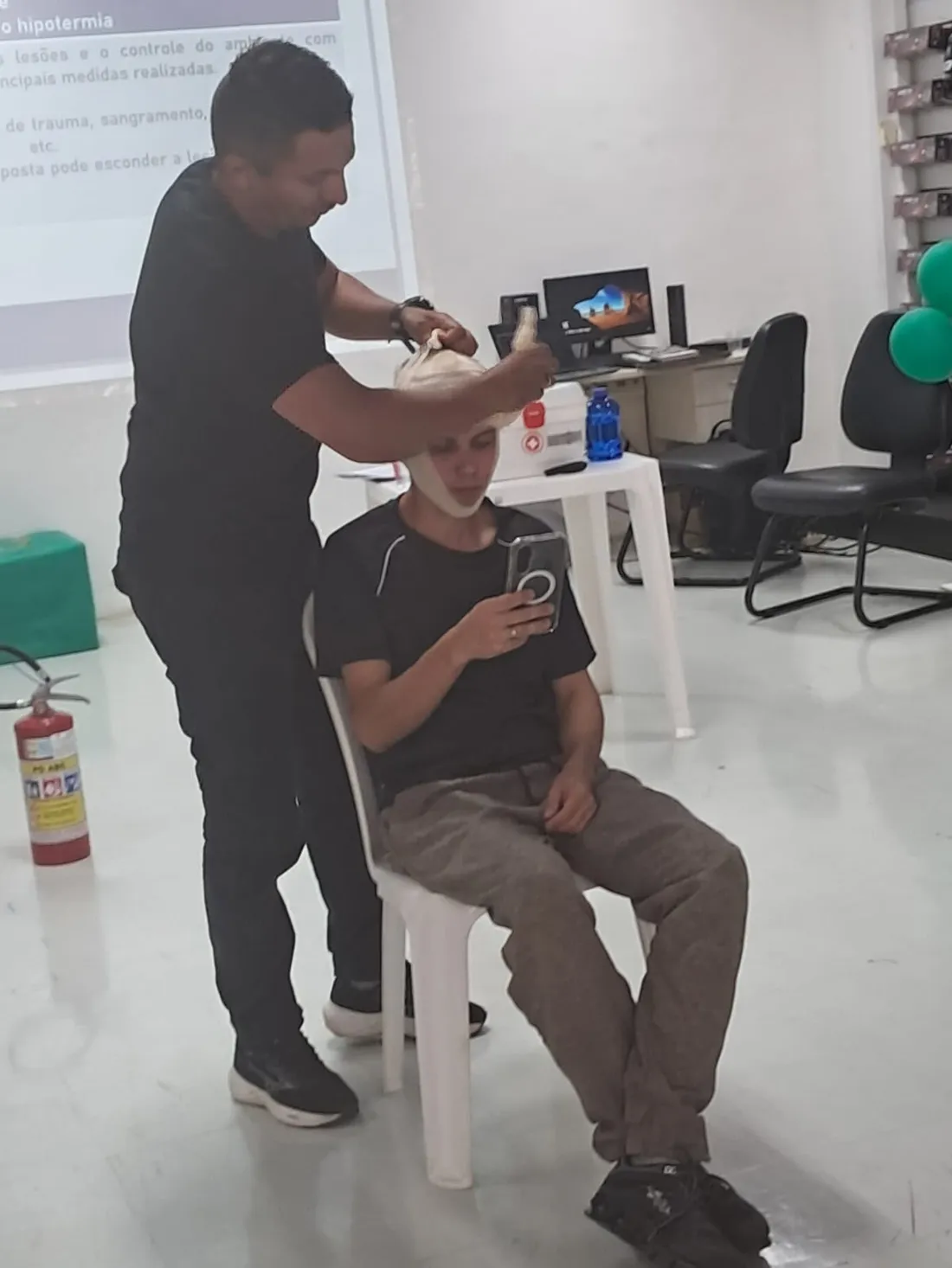 Instrutor demonstrando curativo e imobilização em aula de primeiros socorros